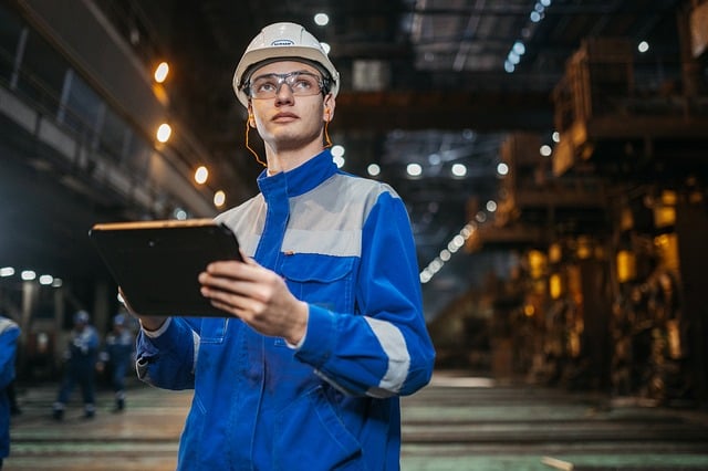 Engineer in Facility with Hardhat and Clipboard Checking Pump Compatibility
